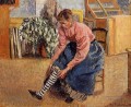 Mujer poniéndose las medias 1895 Camille Pissarro